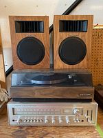 Turntable, receiver, and speakers all arranged together showing wood grain finish and overall set layout.