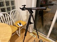 Overall view of Bushnell telescope assembly on tripod with accessories on chair