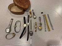 Overview of all watches, watch bands and leather storage box, displayed on a surface