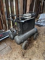 Full view of dual-tank compressor on wheels showing gasoline engine and steel frame