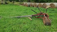 Photo of horse drawn disc harrow showing side view with wooden drawbar and tractor metal seat, rust visible on discs and frame.