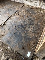 Single rubber mat in stall corner showing surface wear and debris
