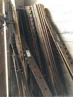 Stack of rusted serrated bars leaning against wall