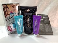 Front view of new GlamGlow skincare set box and three product tubes including black GalacticCleanse cleanser, blue ThirstyMud treatment, and purple GravityMud treatment tubes.