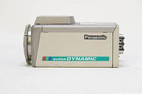 Side view of Panasonic Super Dynamic WV-CP454 color CCTV camera showing model and branding on body; lens mount front visible.