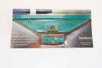 Front view of the TrackMaster picture hanger with level bubble and included components in original packaging.