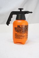 Front view of orange translucent sprayer tank with black pump handle, showing printed text labeling 1/2 gallon capacity and chemical resistance.