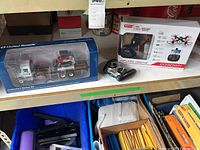 Photo showing the boxed United Rentals model truck and track loader along with the boxed Syma WiFi FPV drone and remote controller on a shelf.