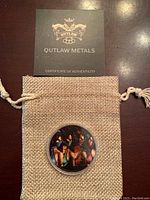 Coin with certificate booklet from Outlaw Metals and pouch