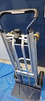 Folded view of hand truck showing silver aluminum frame, black top handle and foot plate