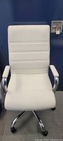Front view of white pleather office chair showing padded seat and backrest with horizontal stitch lines, chrome arms attached.