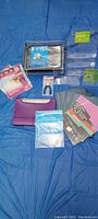 Full overview of various office supplies including organizers, envelopes, paper products, and tools laid on a blue fabric background.