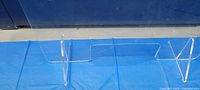 Clear plexiglass counter shield laid flat showing support legs and entire panel.