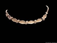 Full view of the necklace showing linked rectangular rhinestone segments and smaller clusters forming a choker shape.