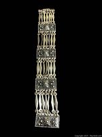 Full view of the silver bracelet showing all four decorative square panels and linked sections.