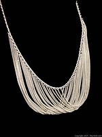 Front view of vintage silver drape necklace against black background showing the layered chains.