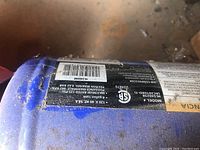 Close-up of Campbell Hausfeld air compressor label showing model HL540298 and specifications including 120V, 60 Hz, 14A, and maximum rated 125 PSI/8.62 bar