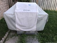 Master Forge propane BBQ grill covered with a white GrillPro cover.