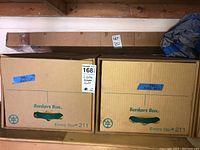 Two Bankers Boxes labeled 'Bike Parts' containing miscellaneous bike parts.