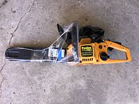 Full side view of Poulan 210 PRO Super Clean chainsaw with plastic wrap around bar and handle. Unit sits on concrete floor.
