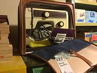 Janome sewing machine inside brown carrying case with some accessories visible