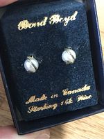 Pair of sterling silver stud earrings with pearl-like center, made in Canada, marked as sterling first silver