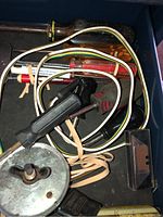 Inside view of toolbox drawer showing various hand tools including screwdrivers, an electrical test lead with wires, and other small tools.