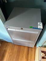 Front and top angled view of gray metal 2-drawer filing cabinet showing handles and lock.