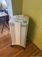 Overall front view of IQAir HealthPro Series air purifier on rolling base in a room