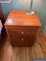 Wood night stand with 3 drawers, drawers closed showing condition and surface details.