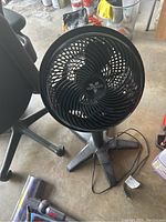 Front view of Vornado fan showing circular grill with blades and power cord on the ground.