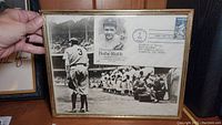 Framed photo of Babe Ruth in Yankees uniform with first day issue stamp honoring him attached in top right corner.