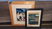 Two framed baseball memorabilia items side by side on couch, including color signed photo and lithograph