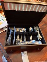 Wooden box containing assorted Towle and other flatware pieces arranged in slots