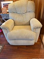 Front view of La-Z-Boy reclining rocker chair, showing padded back, arms, and seat in beige textured fabric.