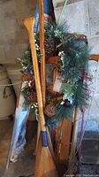 Photo showing the wooden oars alongside the Flexible Flyer sled decorated with Christmas greenery and pinecones