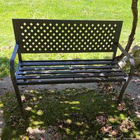 Front view of black metal outdoor bench showing lattice backrest and slatted seat.