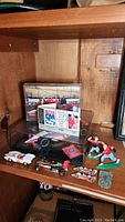 Photo showing multiple items including racing pin collection, race car models, Matchbox-sized cars, baseball figures, and framed photo