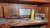 Wooden cabinet Luxtone radio with control knobs and frequency display along with Tokai and Suntone handheld radios placed beside it.