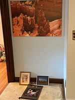 Bryce Canyon landscape photograph on wall and five other framed pieces on floor