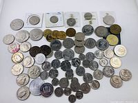 Top-down view of the full lot showing an assortment of collectible coins in different styles and conditions.