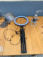 Full view of all three items including ring light on tripod stand, Blue Snowball microphone on shock mount, and old metal spotlight.