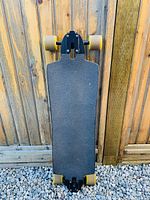 Top view of the longboard deck showing black grip tape and overall length and shape.