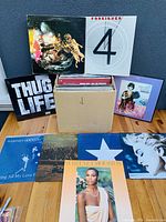 Photo showing a selection of record albums including Foreigner 4, Thug Life, and box of assorted records