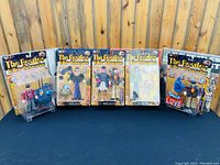 Front view of all five unopened Beatles Yellow Submarine action figures in original blister packaging.