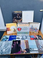 Photo showing multiple vinyl album covers including Jethro Tull's 'Songs From The Wood', Neil Diamond, Diana Ross, Supremes, and others arranged on a table.