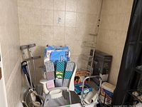 Corner shot showing overall contents: crutches, toilet paper, shower seat, back supports, tissue boxes, and grab bar basket pole