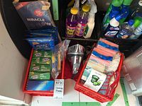 Photo of general lot contents with cleaning supplies and Hamilton Beach iron visible