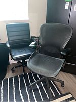 Two chairs side by side on caster bases in room against wall