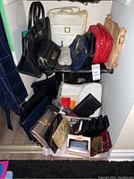 Photo showing the full collection of purses, handbags, wallets, and coin pouches stacked on shelving including various designs and colors.